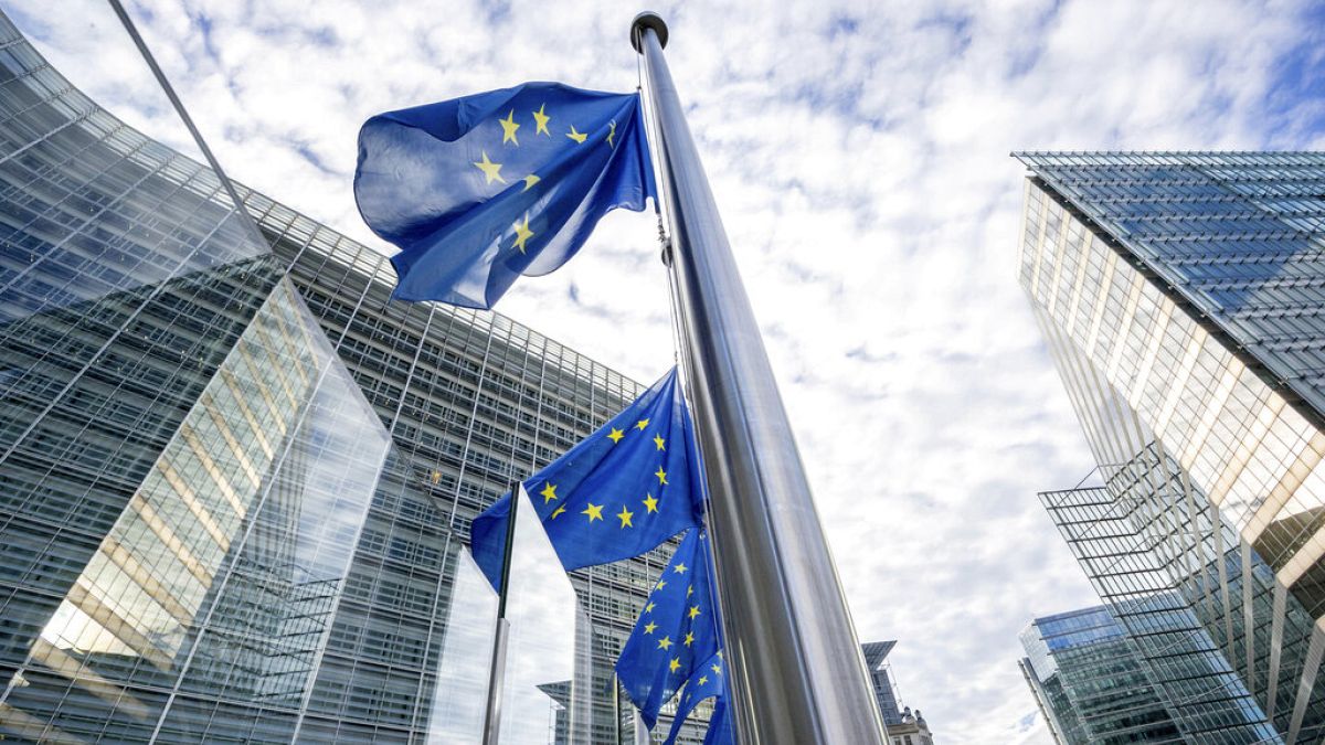 European Union flags flap in the wind at half-staff at EU headquarters in Brussels. 
