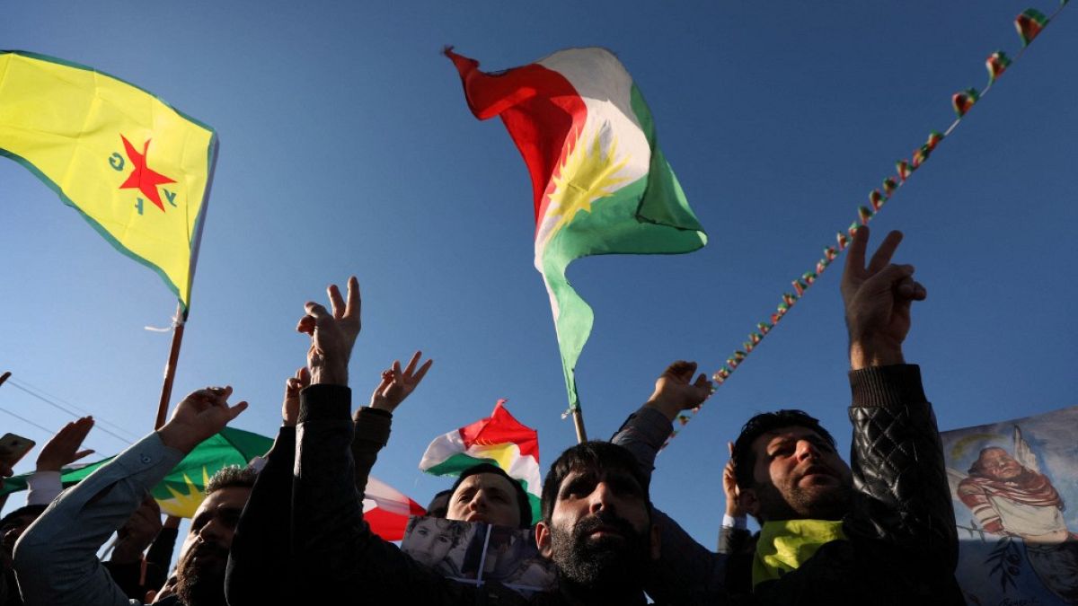 Syrian Kurds wave flags in the northern Iraqi city of Arbil, during a demonstration on February 2, 2018.