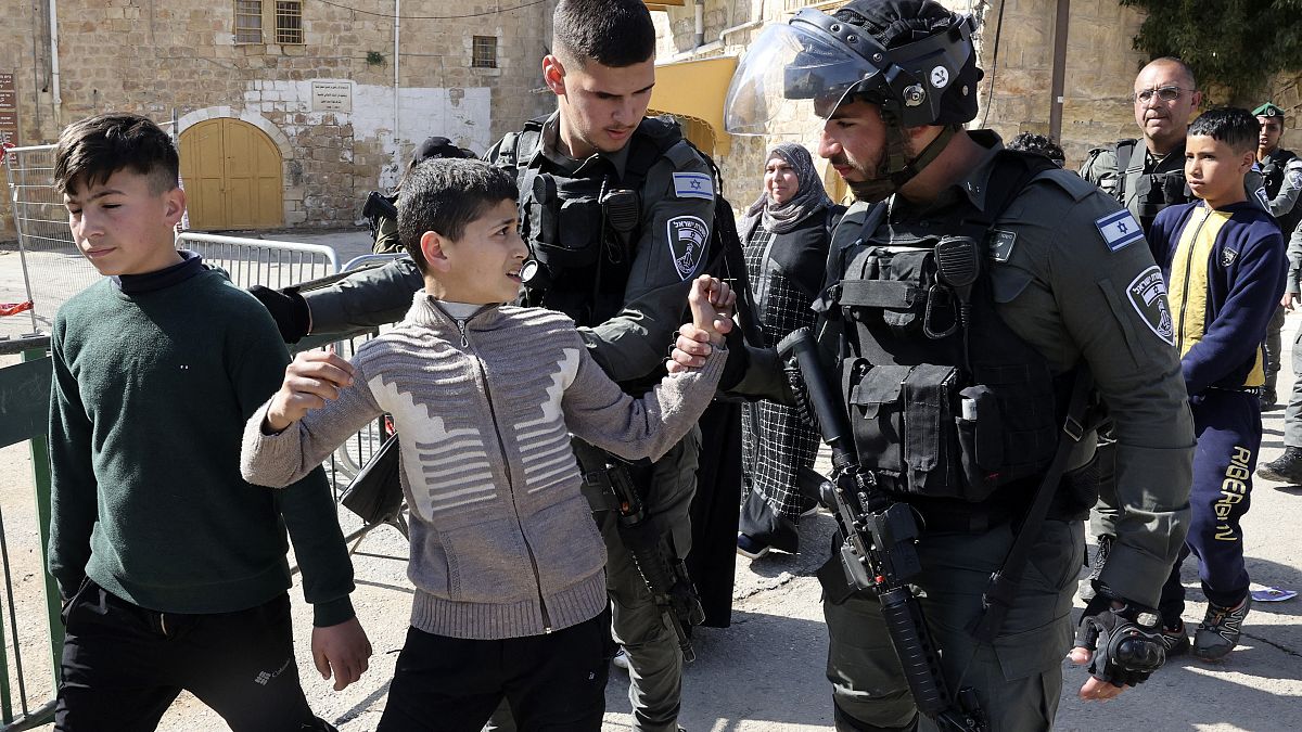 جندي إسرائيلي يمسك بطفل فلسطيني في محيط الحرم الإبراهيمي. 2022/02/28