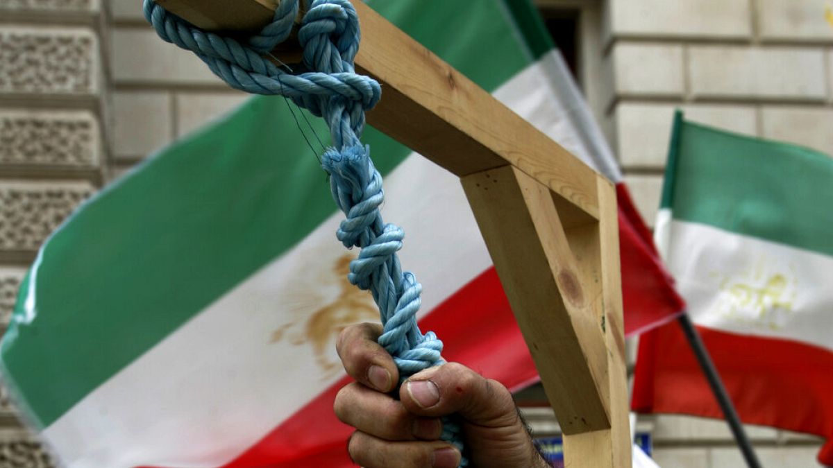 Mão segurando uma corda, num cadafalso, no Irão