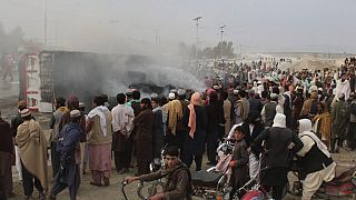 أشخاص يتجمعون حول شاحنة محترقة بعد أن أطلقت قوات طالبان قذائف مورتر على بلدة شامان الحدودية الباكستانية- 11 ديسمبر 2022.