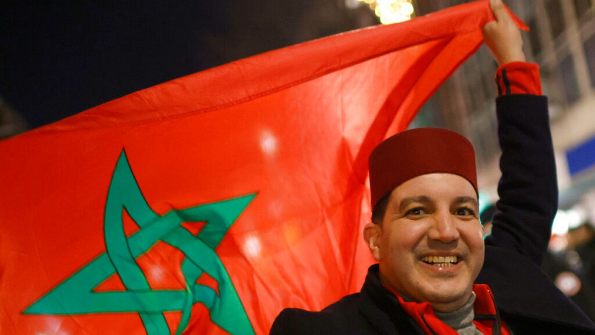 Un supporter marocain célèbre la victoire de son équipe en brandissant le drapeau du Maroc, 10 décembre 2022