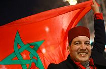 Un supporter marocain célèbre la victoire de son équipe en brandissant le drapeau du Maroc, 10 décembre 2022