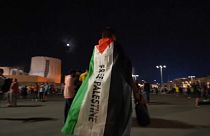 Fußballfan mit Flagge, auf der "Freiheit für Palästina" gefordert wird