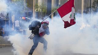 Un partidario del derrocado presidente Pedro Castillo devuelve un bote de gas lacrimógeno a la policía en Lima, Perú, el lunes 12 de diciembre de 2022.