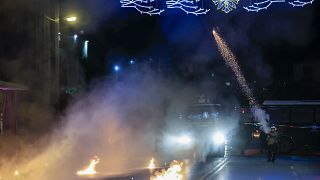 A policeman try to disperse protesters during a rally in the northern city of Thessaloniki.