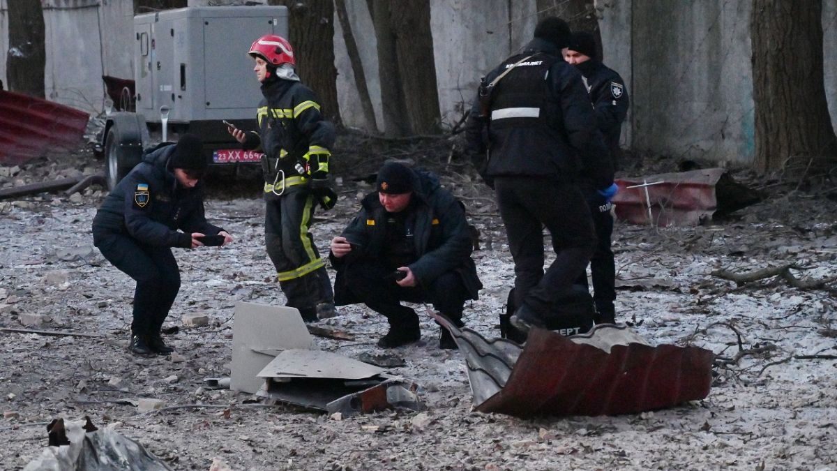 Rescuers and police experts examine remains of a drone following a strike on an administrative building in the Ukrainian capital Kyiv on December 14, 2022.