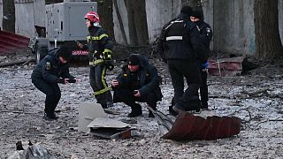Rescuers and police experts examine remains of a drone following a strike on an administrative building in the Ukrainian capital Kyiv on December 14, 2022.