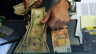 A cashier changes a 50 Euro banknote with US dollars at an exchange counter in Rome, July 13, 2022.