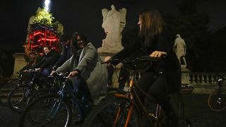 Municipal councilors pedal during the inauguration of Christmas tree powered with bicycles in front of Rome's town hall Campidoglio, Tuesday, Dec. 13, 2022
