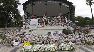 Flowers pile up at a makeshift memorial in a park on the Nice's famed Promenade des Anglais.