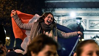 Woman cheers on from the Champs Elysées after France beat Morocco 2-0