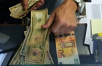 Eine Kassiererin wechselt an einer Wechselstube in Rom einen 50-Euro-Schein in US-Dollar