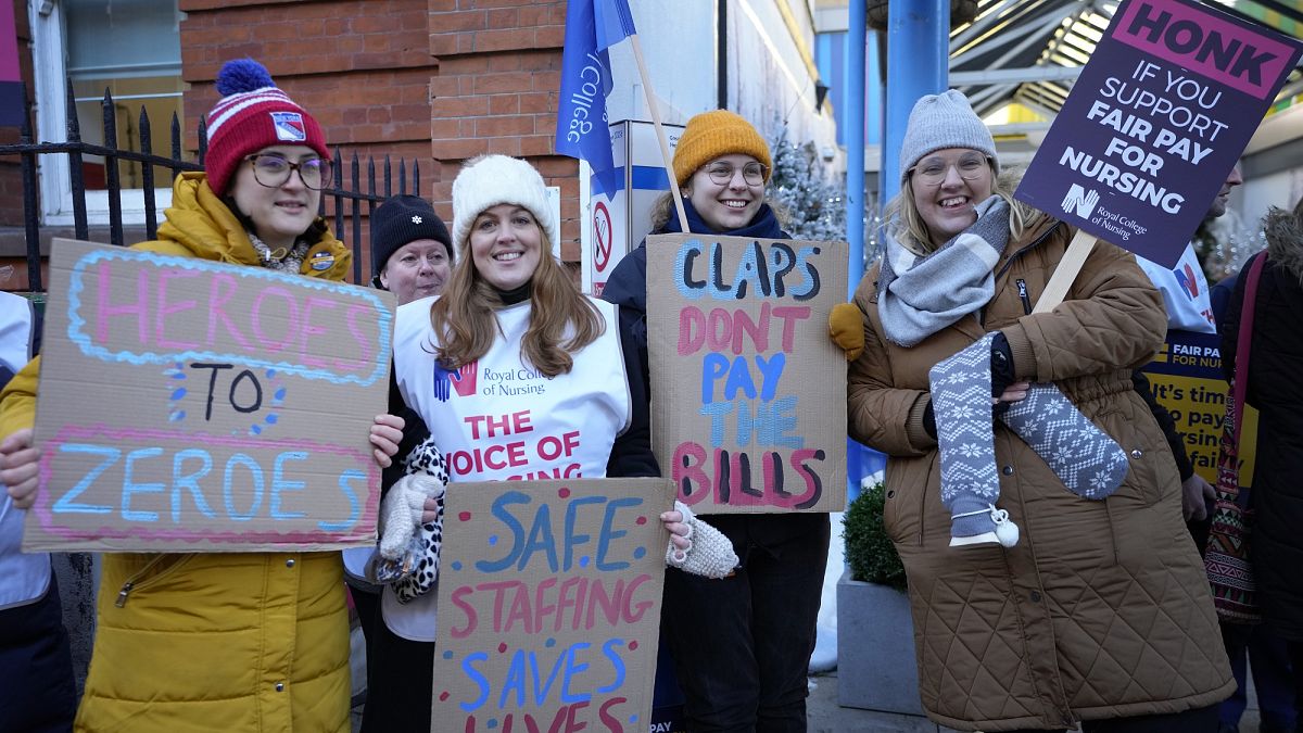 Nővérek transzparensekkel egy londoni kórház előtt