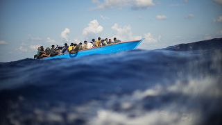 صورة أرشيفية لمهاجرين في قارب خشبي أثناء عبورهم البحر المتوسط باتجاه جزيرة لامبيدوزا الإيطالية، 11 أغسطس 2022.