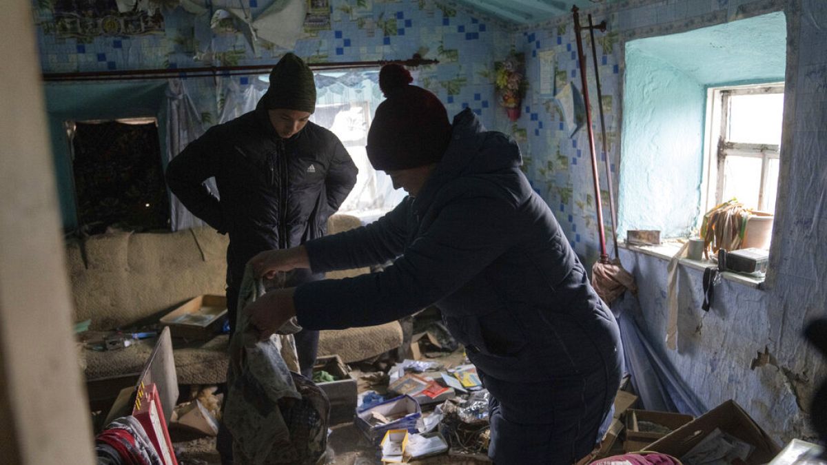 FILE - A family look through their possessions at their house which was occupied by Russian forces, in recently liberated village of Pravdyne, Kherson region, Ukraine, Tuesday