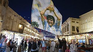 A fan of Argentina waves a flag with the image of late Argentinean soccer star Diego Maradona in Souq Waqif market in Doha, Qatar, Thursday, Dec. 15, 2022