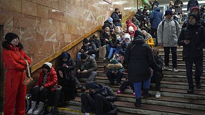 Des personnes se reposent dans une station de métro, utilisée comme abri anti-bombe lors d'une attaque à la roquette à Kiev, en Ukraine, vendredi 16 décembre 2022.