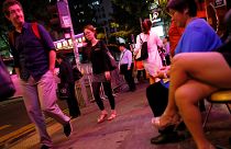 Nyugati turista figyel egy prostituáltat Hongkong vigalmi negyedében