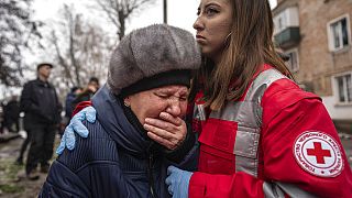 A woman cries in front of the building which was destroyed by a Russian attack in Kryvyi Rih, Ukraine, Friday, Dec. 16, 2022.