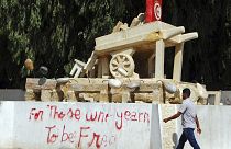 شاب تونسي يمر بجانب مجسم لعربة البائع المتجول محمد بوعزيزي الذي أشعل الثورة التونسية