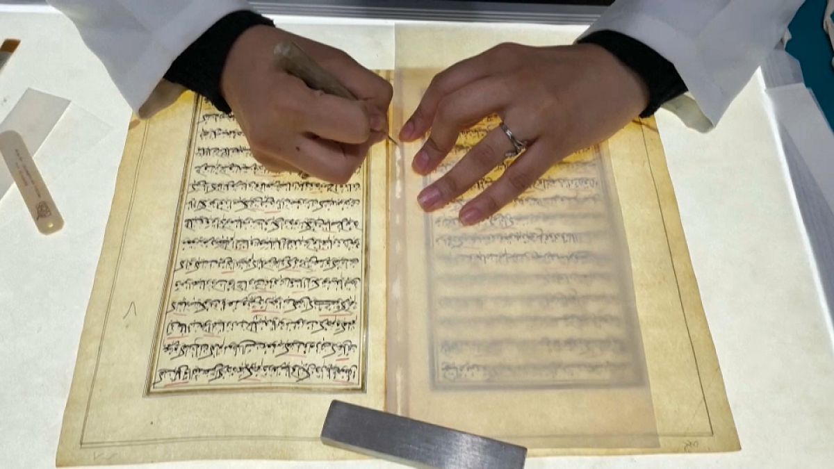 In an annex of Iraq's national museum, a conservator pores over a 17th-century manuscript