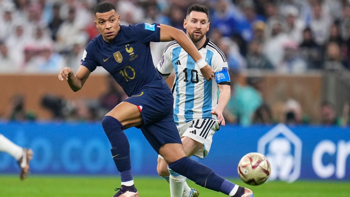 France's Kylian Mbappe and Argentina's Lionel Messi go for the ball during the World Cup final soccer match between Argentina and France