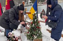 The family of a fallen Ukrainian soldier decorate Christmas tree on his grave in Lviv, Ukraine.