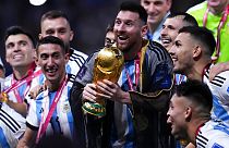 Argentina captain Lionel Messi surrounded by teammates as he holds the World Cup