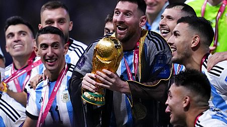 Argentina captain Lionel Messi surrounded by teammates as he holds the World Cup