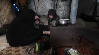 Syrian family trying to stay warm in winter.