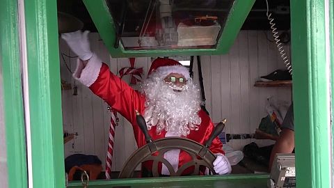 Santa Claus delivers presents to children in poor villages along the Amazon