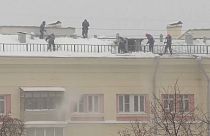Operarios quitan la nieve de un tejado tras la enorme nevada de Moscú