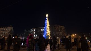 الناس يحضرون تدشين شجرة عيد الميلاد المزينة بألوان العلم الوطني الأوكراني في كييف، أوكرانيا، يوم الاثنين، 19 ديسمبر/كانون الأول 2022.
