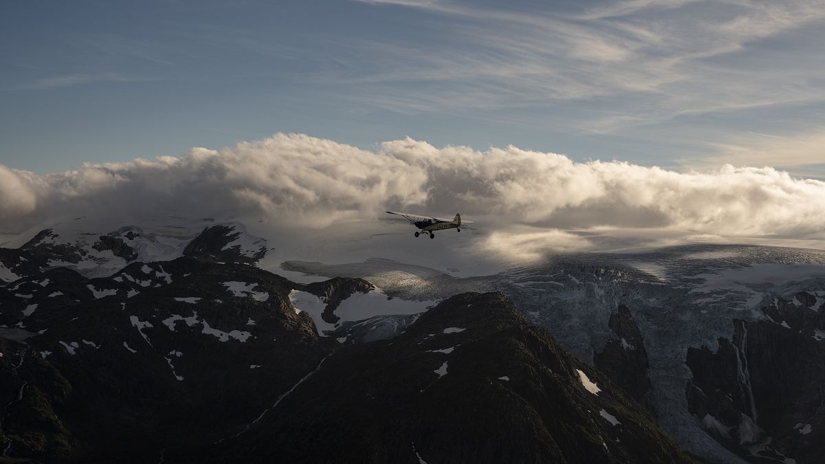 O monomotor Piper Super Cub, de Garrett Fisher, sobrevoando os glaciares da Noruega