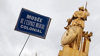 A sign reading "Museum of Colonial Mental Space" is displayed during a "de-colonial tour" of monuments tied to the slave trade or colonial-era abuses in Paris, July 5, 2020.