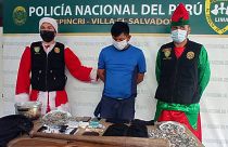 Polícias disfarçados de Pai Natal e duende de Natal com um traficante detido