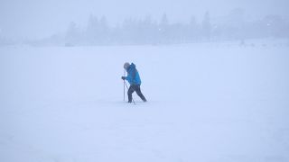 Ein Mann im Schnee auf Skiern bei Reykjavik, Island