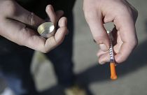 In this Oct. 22, 2018 file photo, a fentanyl user holds a needle near Kensington and Cambria in Philadelphia.