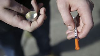 In this Oct. 22, 2018 file photo, a fentanyl user holds a needle near Kensington and Cambria in Philadelphia. 