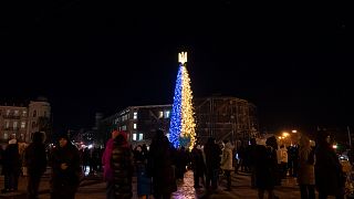 People attend the inauguration of a Christmas tree decorated with the colours of the Ukrainian national flag in Kyiv, Ukraine, Monday, Dec. 19, 2022