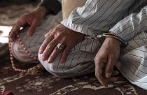 رجل أفغاني محكوم عليه بالإعدام بتهمة القتل، مكبل اليدين إلى سجين آخر، خلال جلسة استماع في محكمة استئناف غزني، في شرق أفغانستان. 2022/11/28