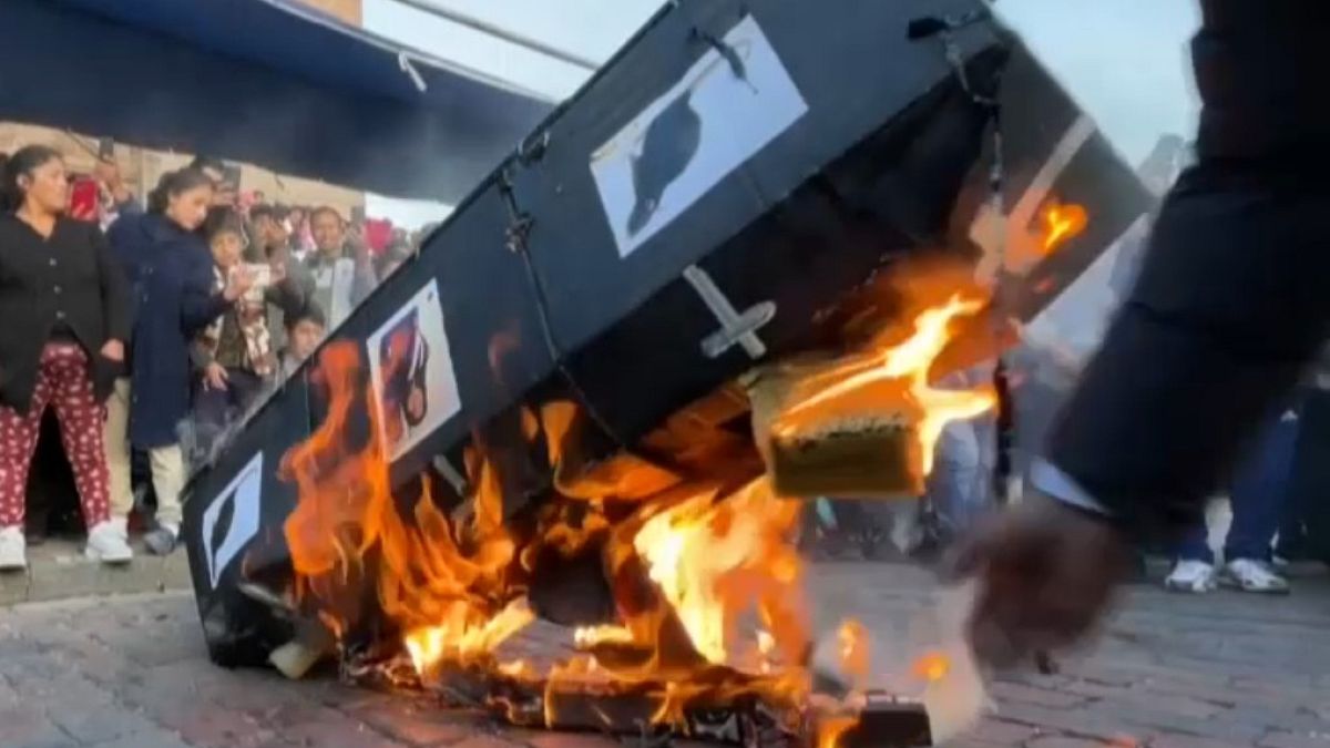 Protesters burn cardboard coffin depicting pictures of politicians and rats in Cusco, Peru.
