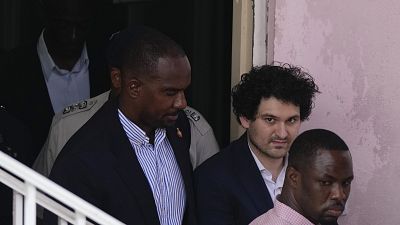 File from December 19 shows FTX founder Sam Bankman-Fried, second right, is escorted out of Magistrate Court toward a Corrections van, following a hearing in Nassau, Bahamas