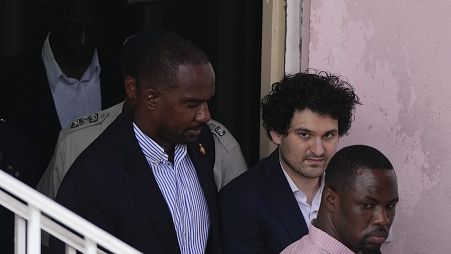 File from December 19 shows FTX founder Sam Bankman-Fried, second right, is escorted out of Magistrate Court toward a Corrections van, following a hearing in Nassau, Bahamas