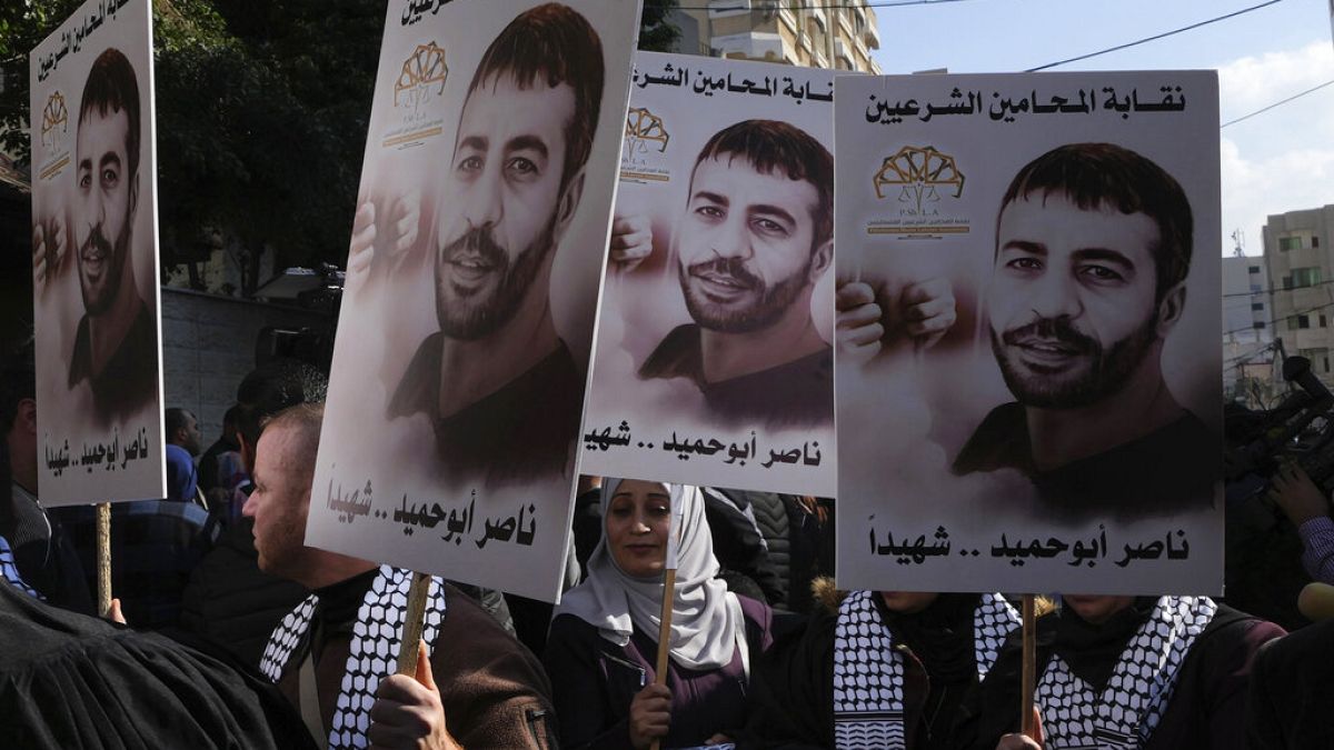 Filistinli göstericiler, İsrail'de bir hapishanede hayatını kaybeden Filistinli Nasır Ebu Hamid'in posterlerini taşırken