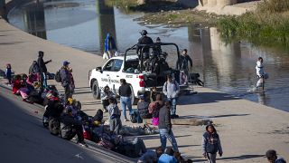 حرس الحدود المكسيكي محاولاً منع المهاجرين من اجتياز النهر والتوجه نحو الولايات المتحدة