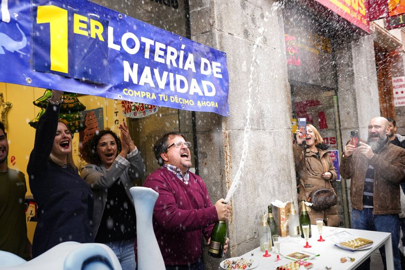 The owner of a lottery administration celebrates the sale of one of the lottery tickets known as "El Gordo"