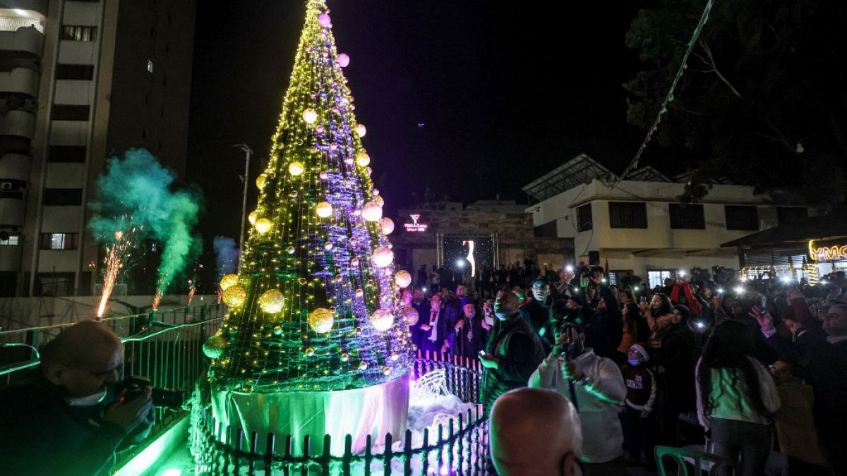 صورة من الارشيف-مسيحيون ومسلمون فلسطينيون  يضيئون شجرة عيد الميلاد في باحة جمعية الشبان المسيحية بغزة