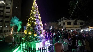 صورة من الارشيف-مسيحيون ومسلمون فلسطينيون  يضيئون شجرة عيد الميلاد في باحة جمعية الشبان المسيحية بغزة